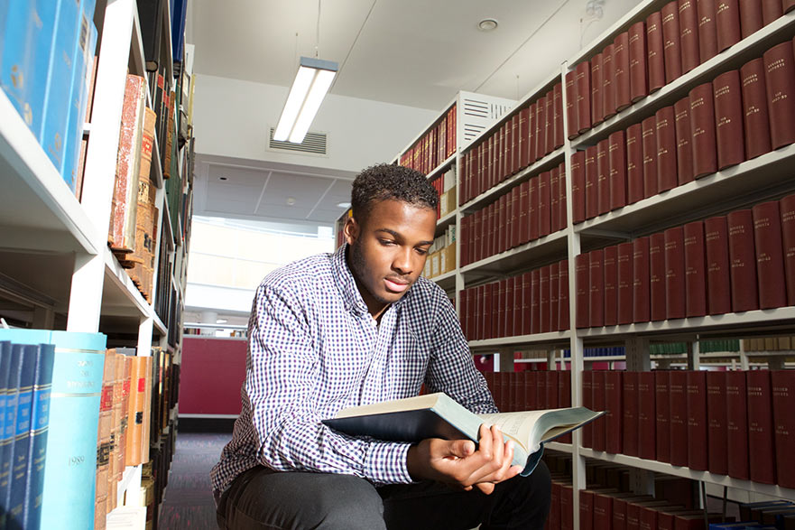 Student reading book in library