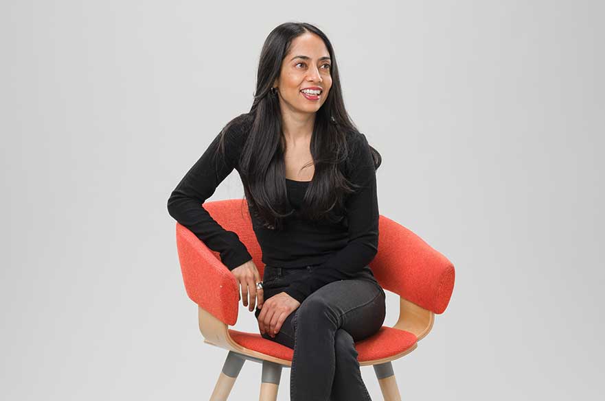 Dr Seema Patel sat on a chair in front of a white background