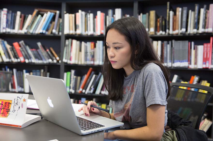 Student using laptop in library