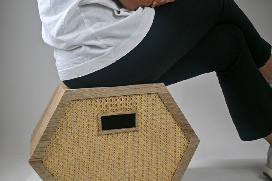A storage box on the floor and someone is sitting on top of it