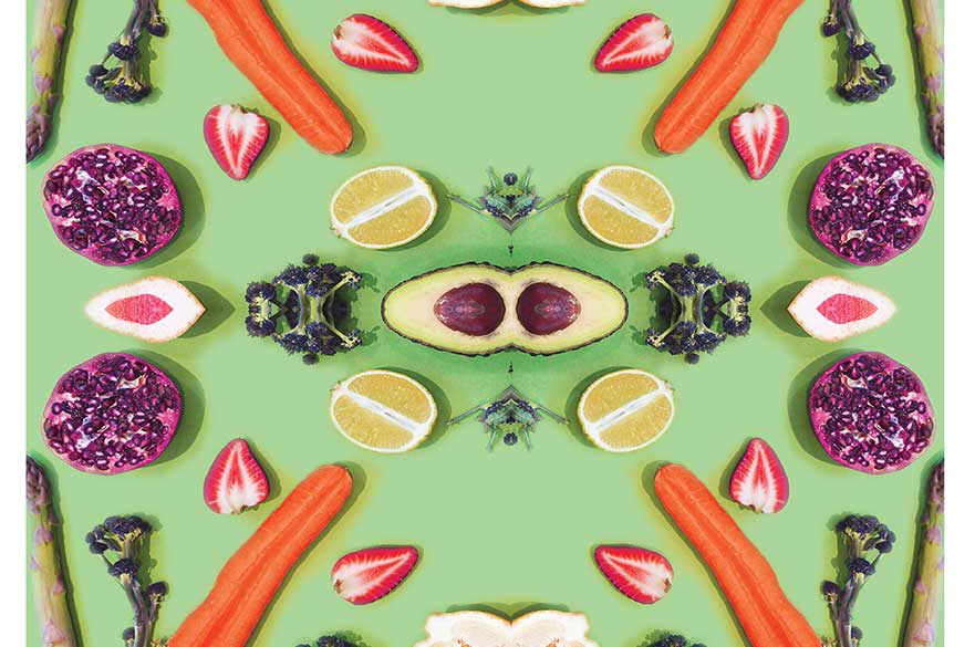 Fruits and vegetables cut in half laid out in pattern