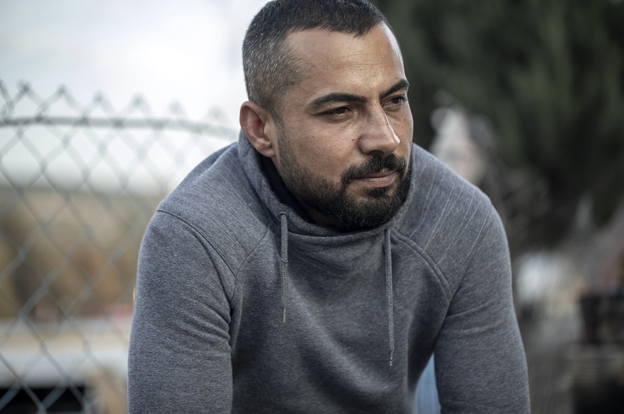 Man sitting outside by a fence