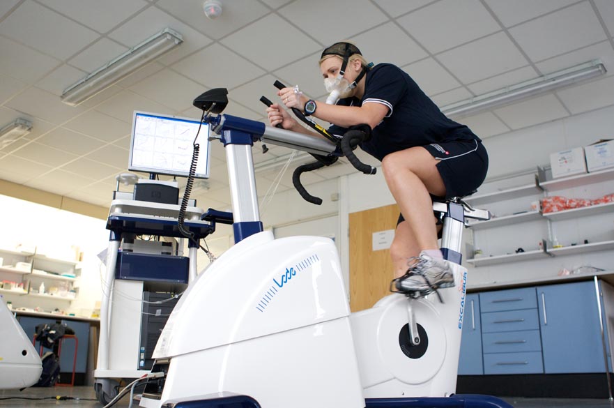 Student on cycling machine using breathing apparatus