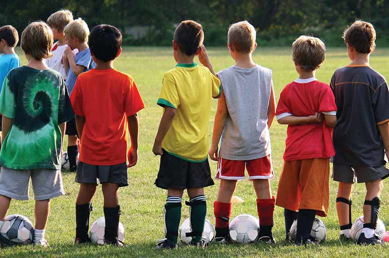 Children standing in a line at football training