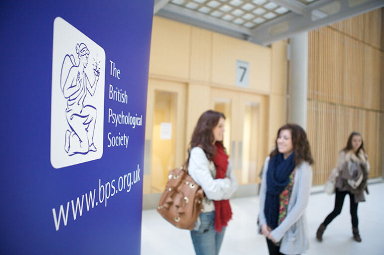Students standing next to a British Psychological Society sign