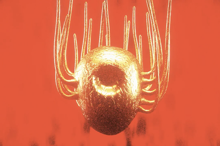 An abstract photo of a gold egg-shaped object with tentacles coming out of it.