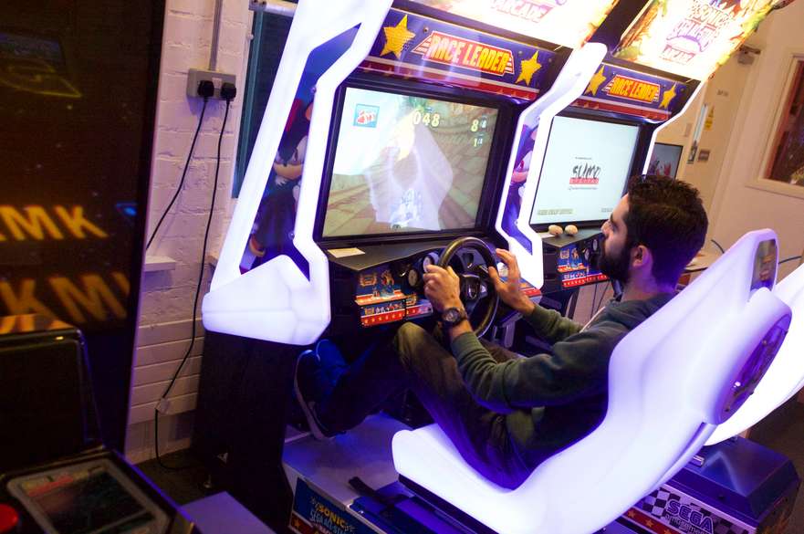 Student playing a racing game in an arcade