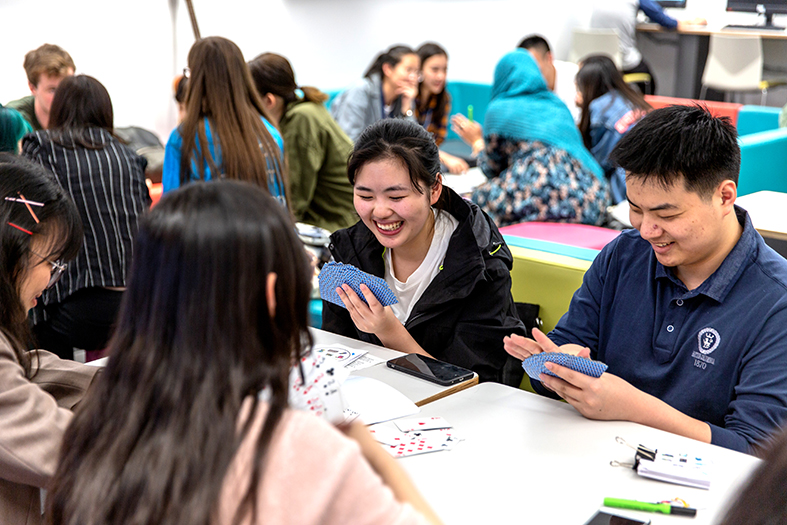 Students playing cards in the Global Lounge