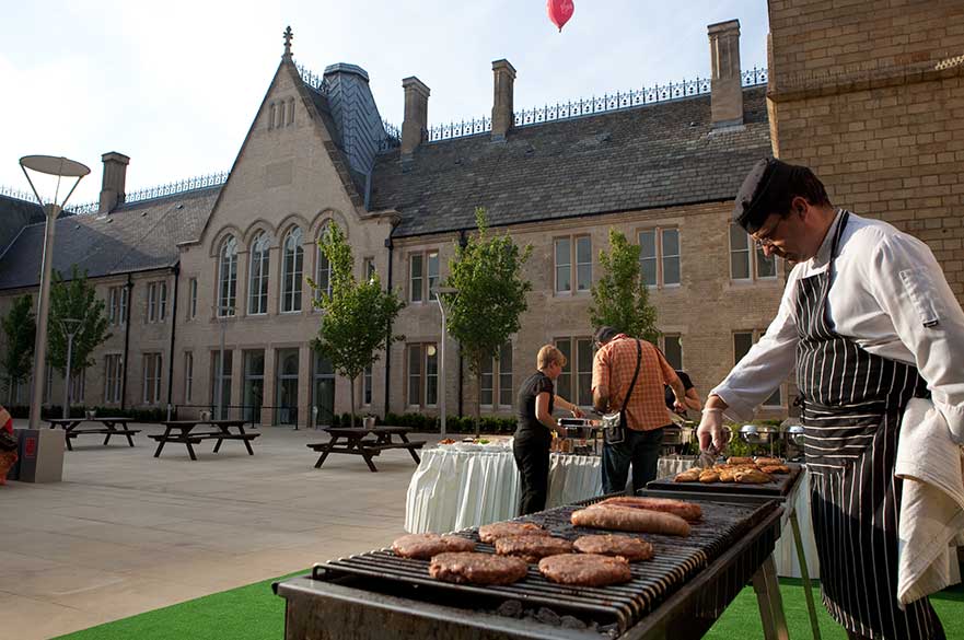 Staff serving BBQ in the City Campus