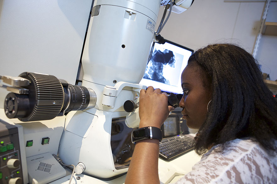 woman in lab using a TEM (Transmission Electron Microscope)