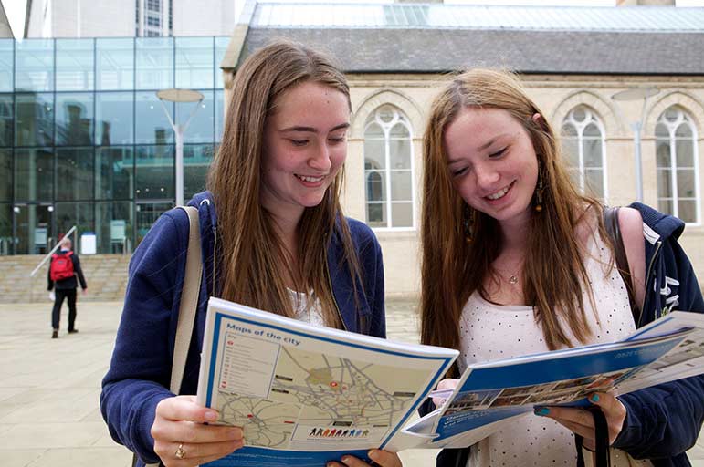 two girls studying a brochure at an NTU open day