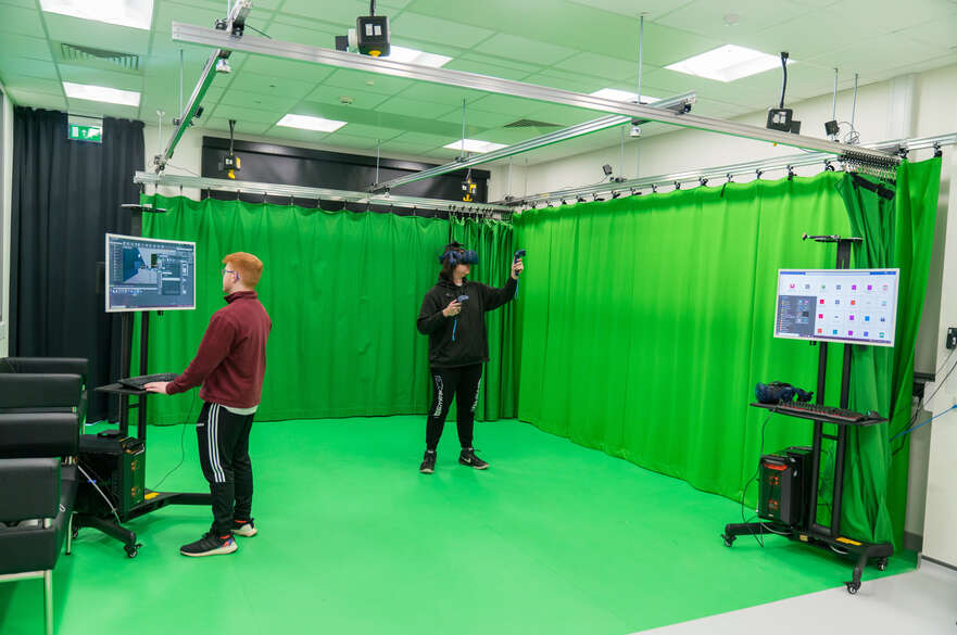 Students with green screen testing the virtual reality game 