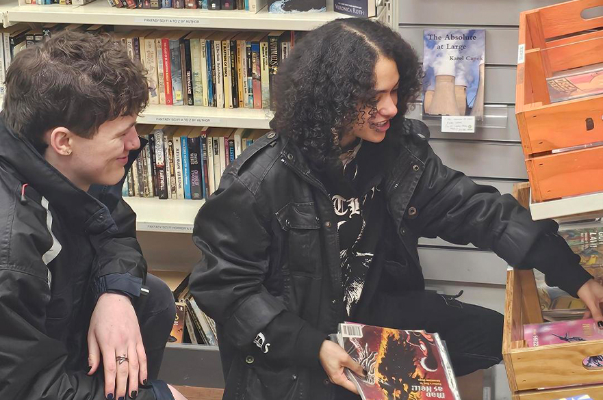 two students smiling while shopping at thrift shop