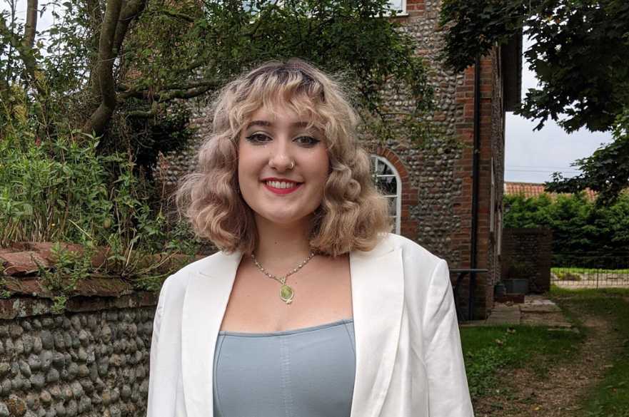 Lucy smiling at the camera in her garden