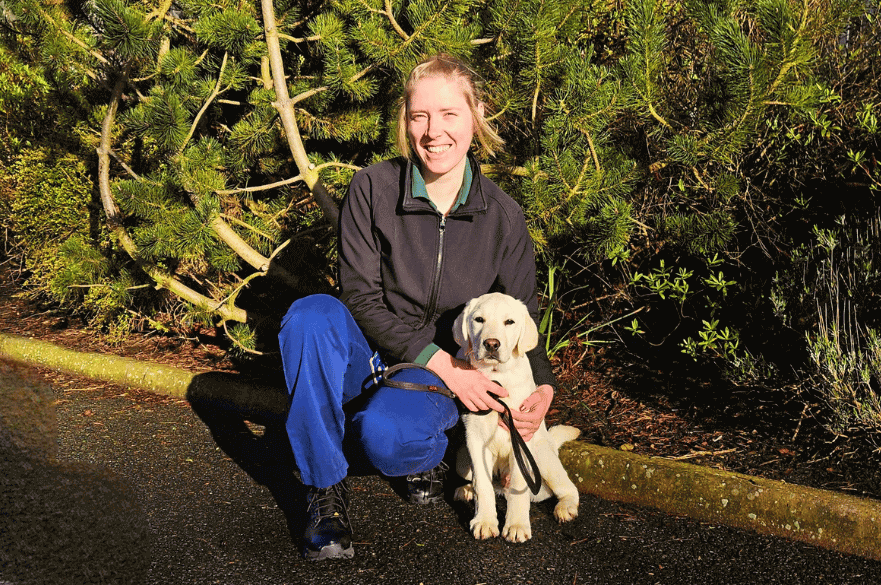 Photo of Molly Malyon with a yellow Labrador puppy