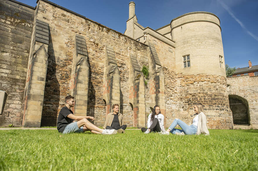 Student sat in the grass next to Nottingham Castle