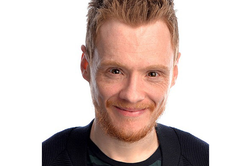 A close-up photo of a man smiling