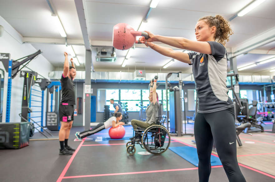 Student lifting a weight in the Clifton sports facilities