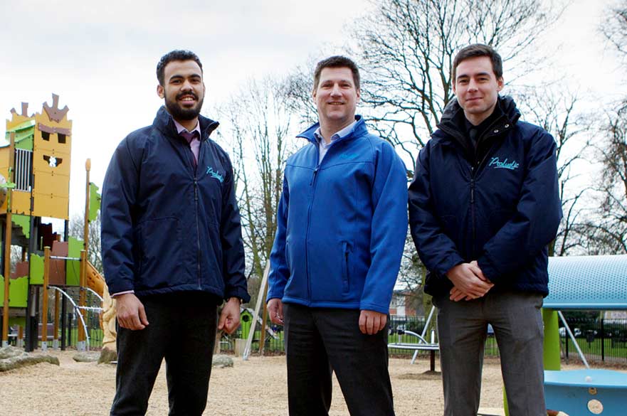 3 men standing in a children's playground