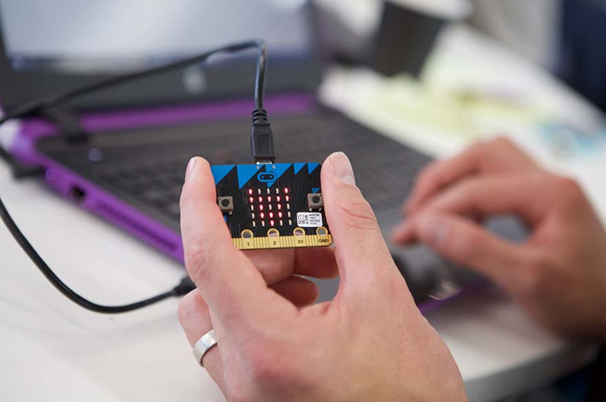 Hand holding a BBC micro:bit computer