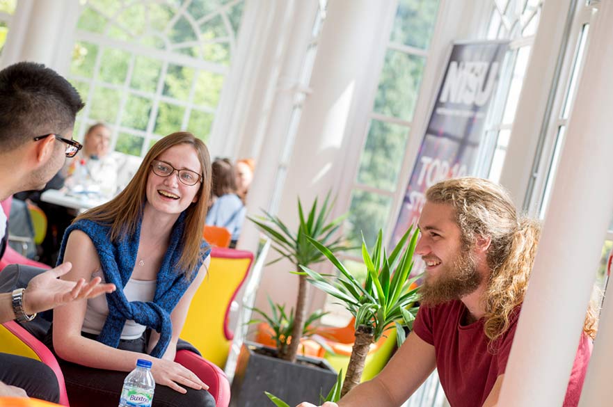 three students sitting talking in orangery cafe on brackenhurst campus