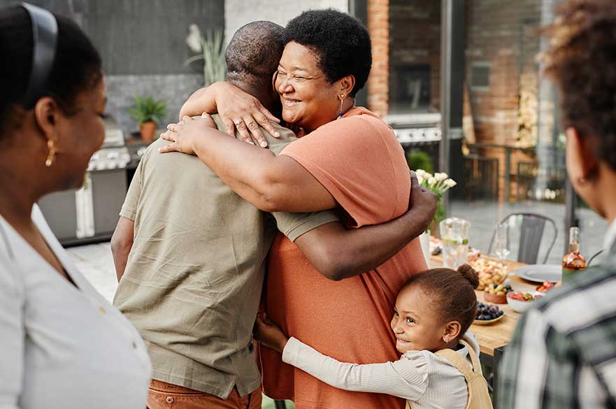 Family group hugging in a kitchen