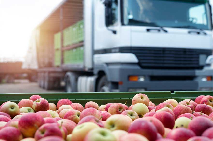 Crate of apples with a lorry in the background