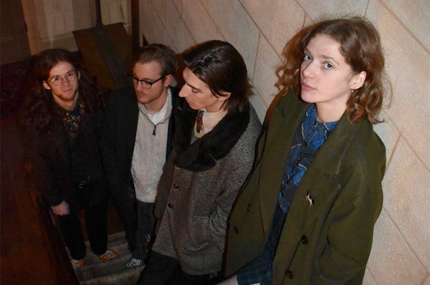 The four members of Grain Mother stood on a flight of stairs, taken from the top.