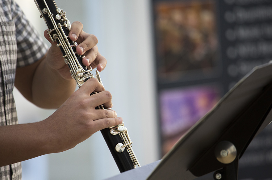 A close up of hands playing a clarinet.