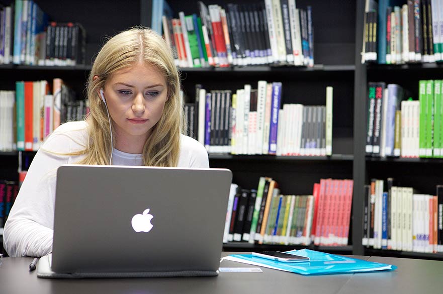 Student in library using laptop