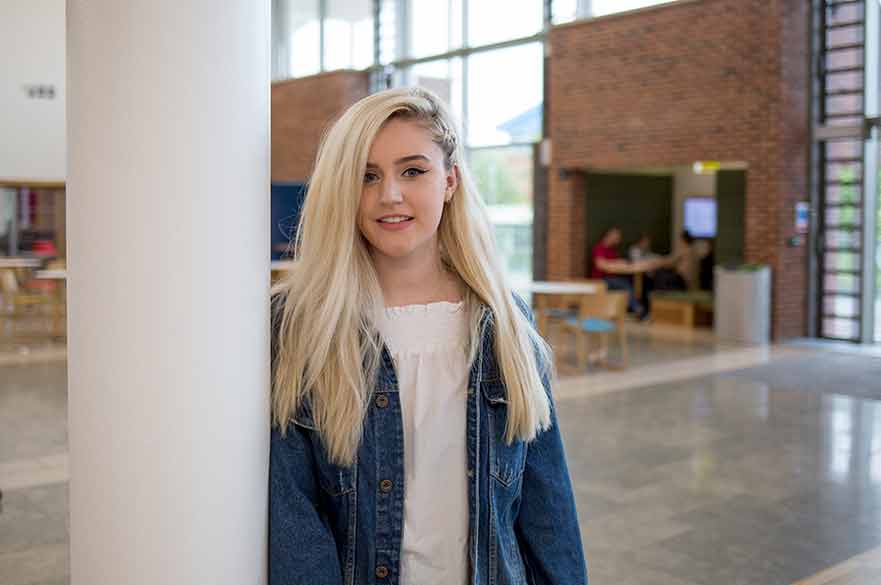 Girl stood against pillar