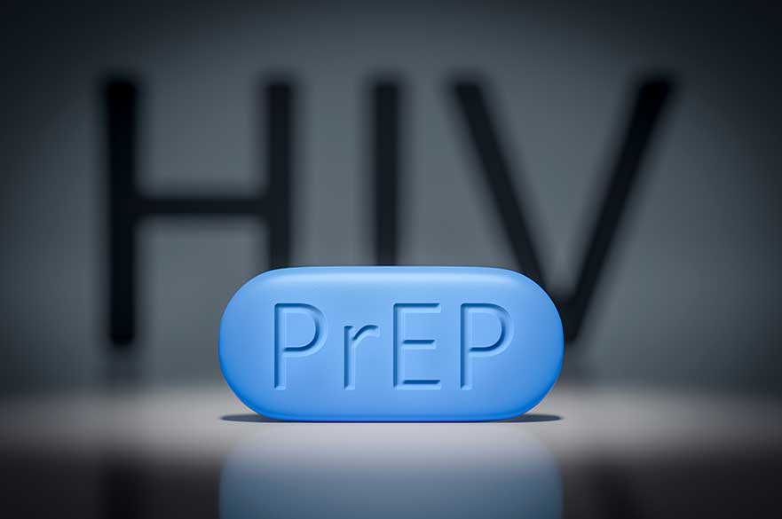 Blue PrEP tablet with the letters HIV blurred in the background
