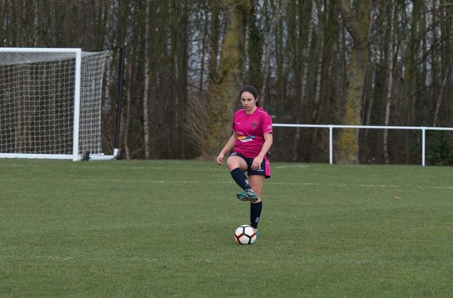 NTU Women's Football player passing the ball