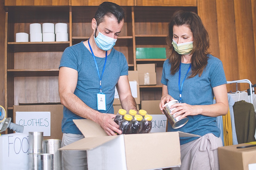 People packing boxes in masks