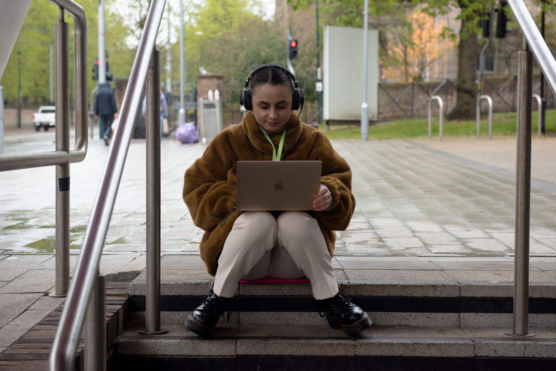 Student sitting on steps working on laptop