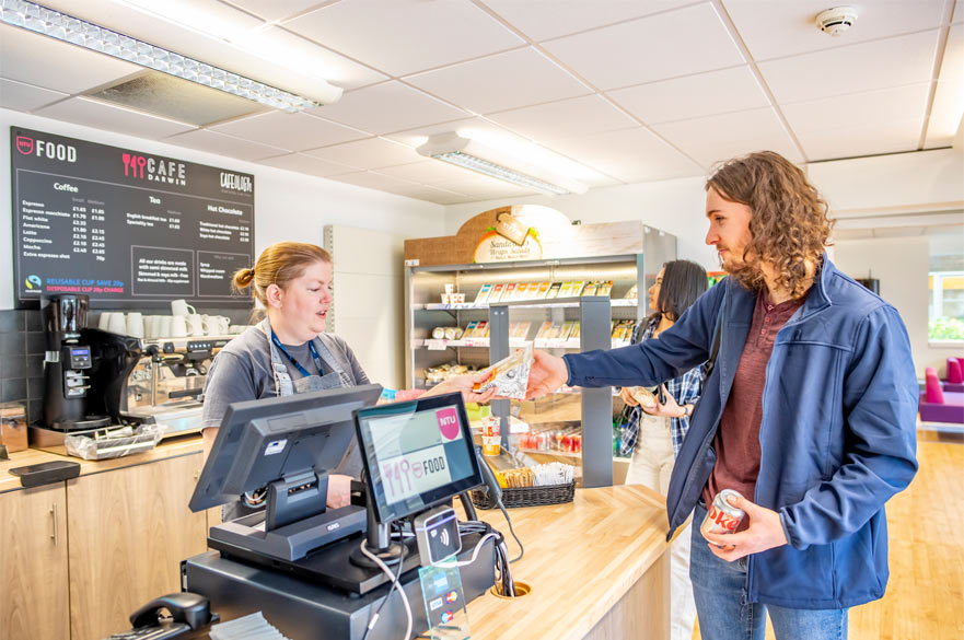 A student paying for his items at the checkout in Cafe Darwin at Clifton Campus