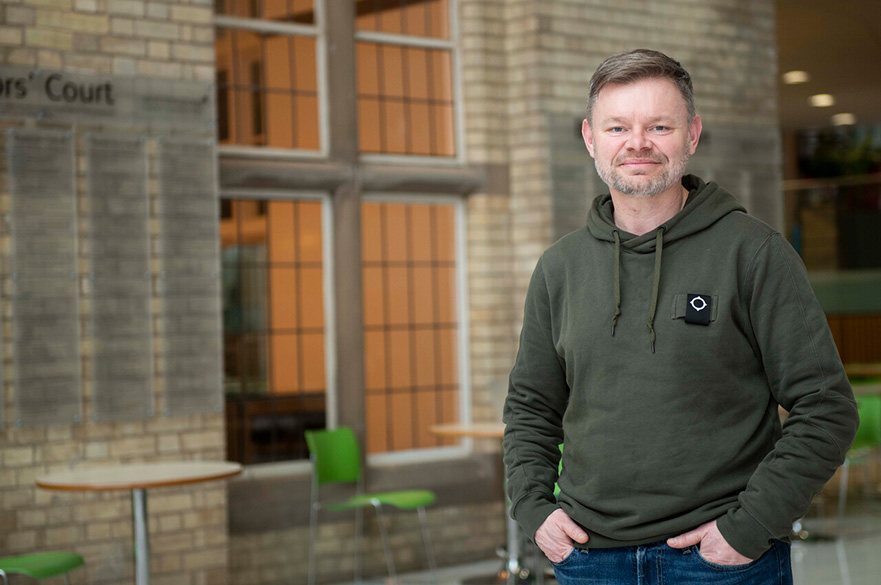Staff profile image for Paul Smith, standing in a green hoodie outside of the Refectory in NTU's Newton Building