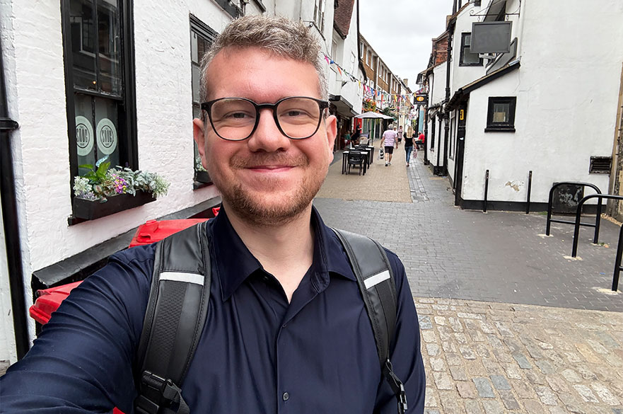 Adam smiling and posing for a selfie on the street