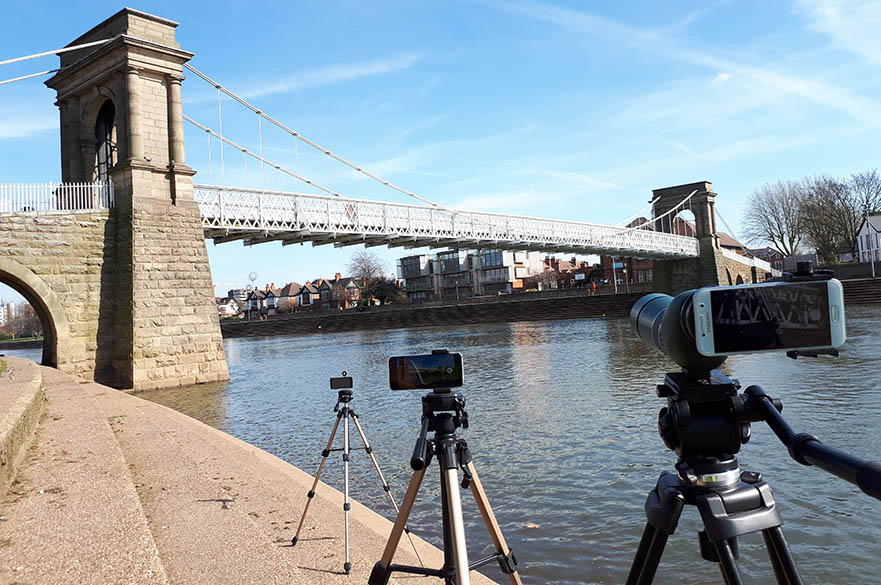 Smart phone on a tripod in front of a bridge
