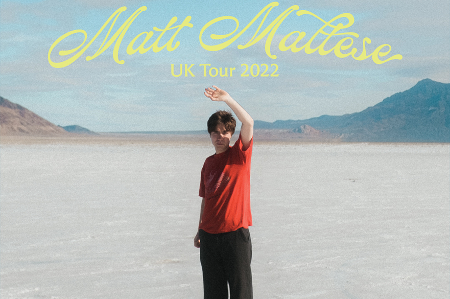 Matt Maltese stood in red looking at the camera.