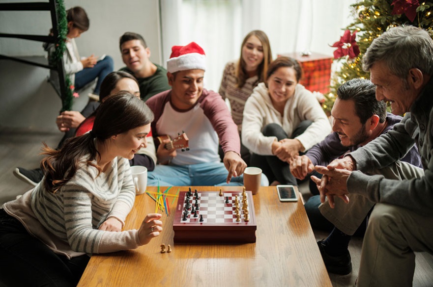 Family sitting around a table playing chess