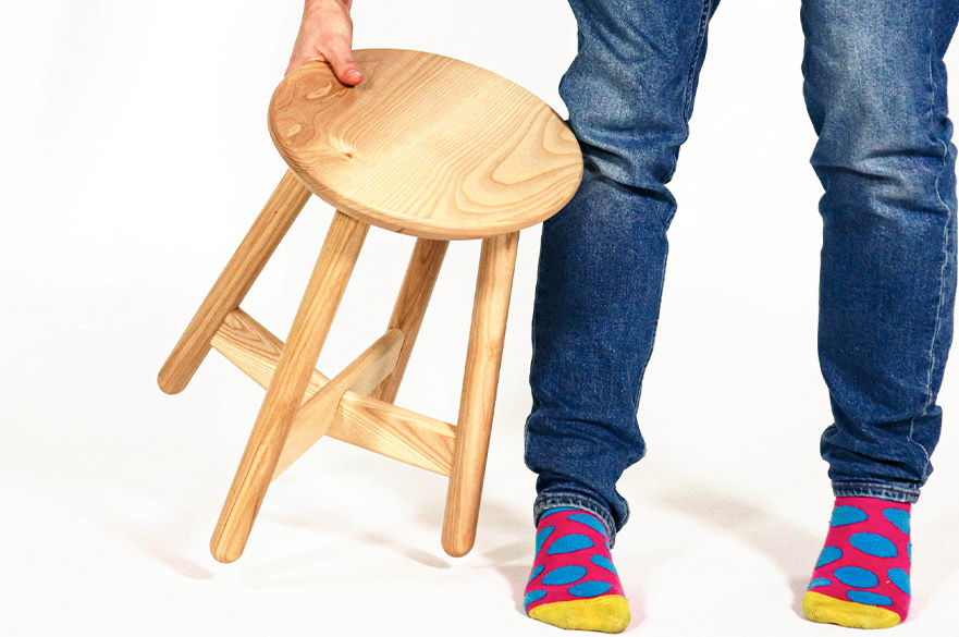 Person holding a wooden stool