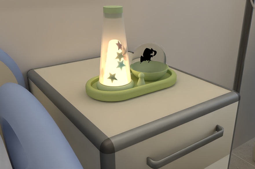 A hospital bed. On the cabinet next to the bed is a tray with two objects on it - therapeutic illuminated toys, one tall, the other smaller and round.