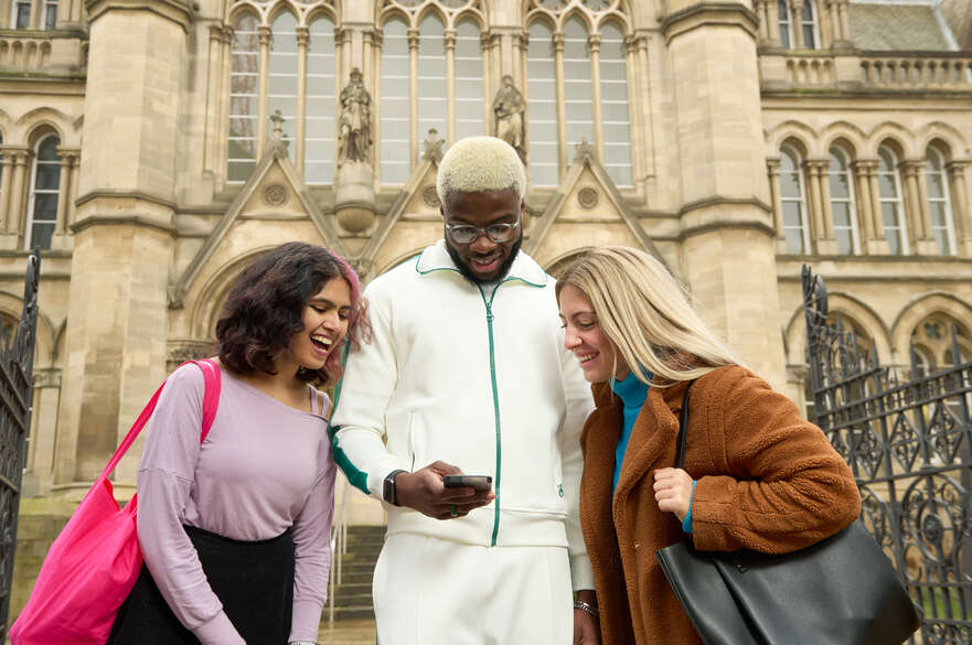 Students looking at a phone outside of Arkwright