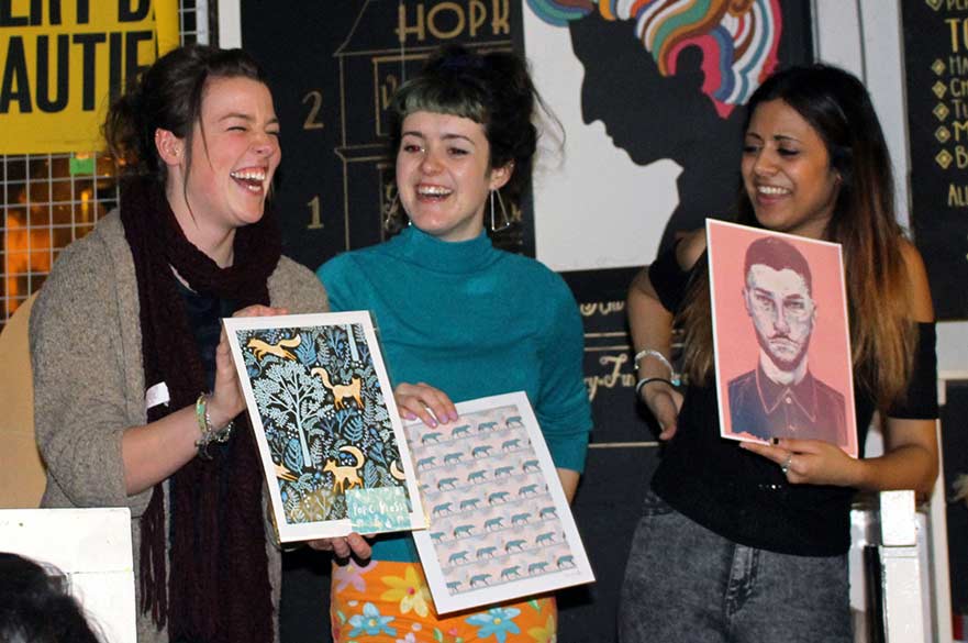 students show off their purchases at art auction