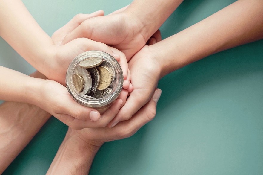 Hands holding a money jar