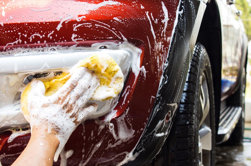 Red car being washed by hand