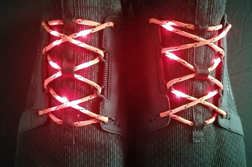 A pair of shoes with flashing red laces. 