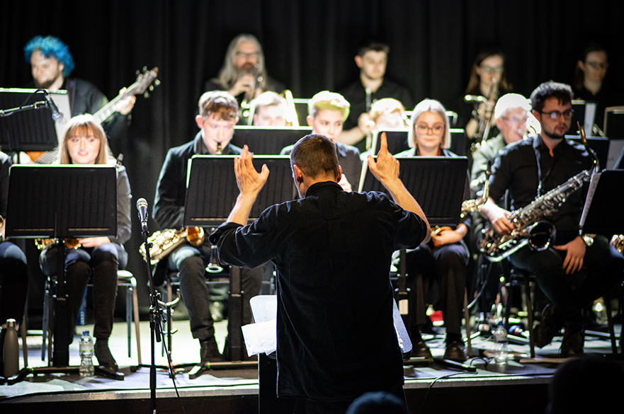 A Big Band on stage with a conductor.