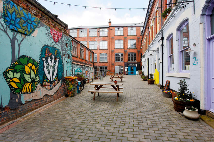 The courtyard at Cobden Chambers, featuring bright wall paintings and strings of fairy lights.